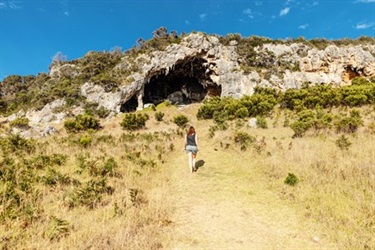 A woman walking towards a cliff