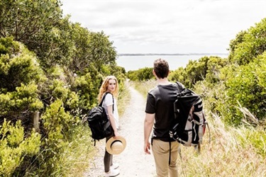 A couple on a path surrounded by trees