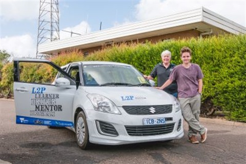 Learner driver and volunteer standing near car